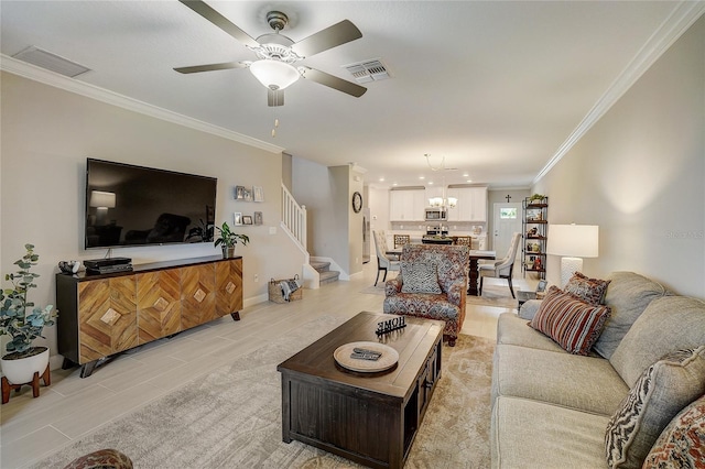 living room with stairway, visible vents, and crown molding