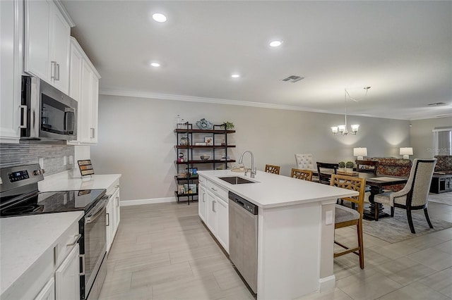 kitchen with visible vents, decorative backsplash, a breakfast bar, stainless steel appliances, and a sink