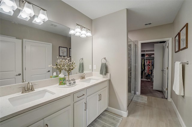 bathroom featuring a stall shower, a sink, and visible vents