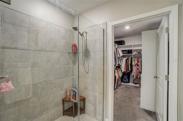 full bath with a spacious closet and a stall shower