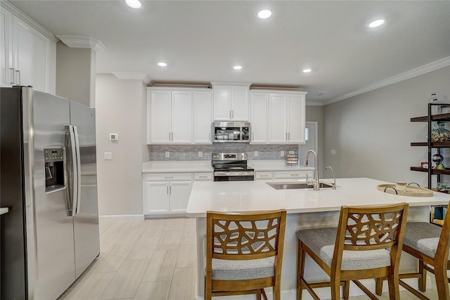 kitchen with crown molding, stainless steel appliances, backsplash, a sink, and a kitchen breakfast bar