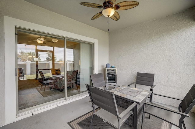 view of patio featuring outdoor dining space, beverage cooler, and ceiling fan