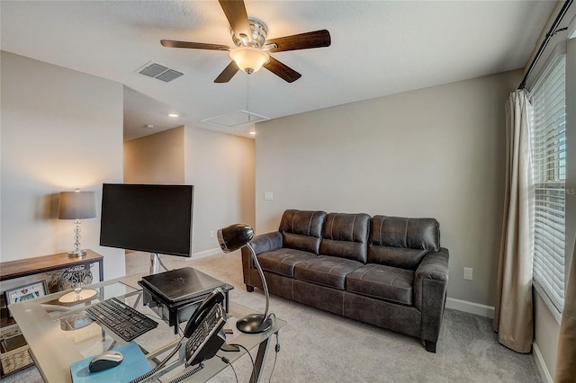 living area featuring light carpet, baseboards, visible vents, and a ceiling fan