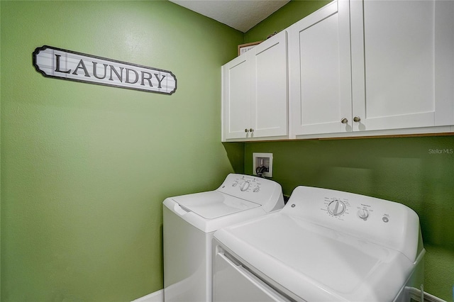 washroom with cabinet space and washer and clothes dryer