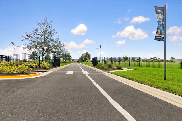 view of road featuring street lighting, traffic signs, and curbs