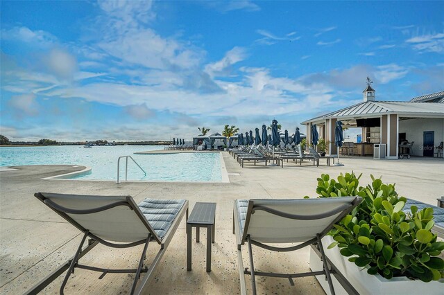 community pool featuring a water view and a patio area