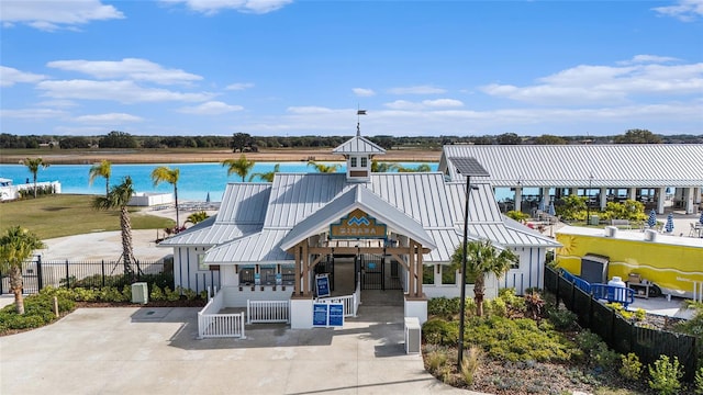 view of building exterior with a water view and fence