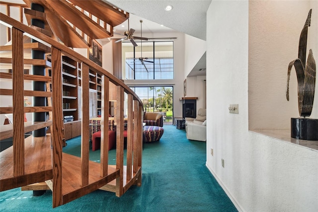 interior space featuring dark colored carpet, high vaulted ceiling, and a textured ceiling