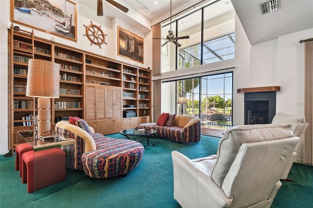 living room featuring carpet, ceiling fan, and a high ceiling