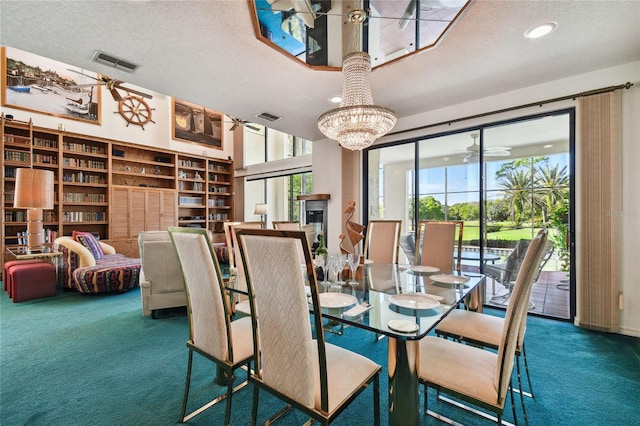 dining area with ceiling fan with notable chandelier, a textured ceiling, and dark carpet