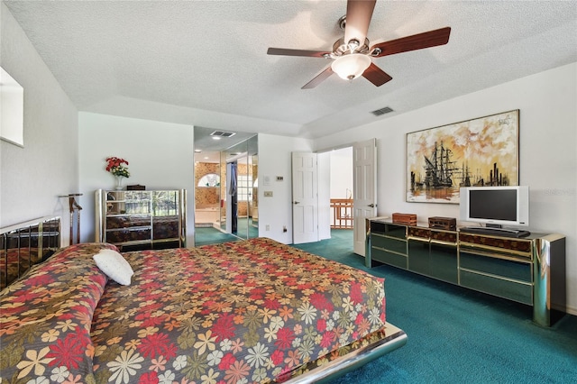 carpeted bedroom featuring ceiling fan and a textured ceiling