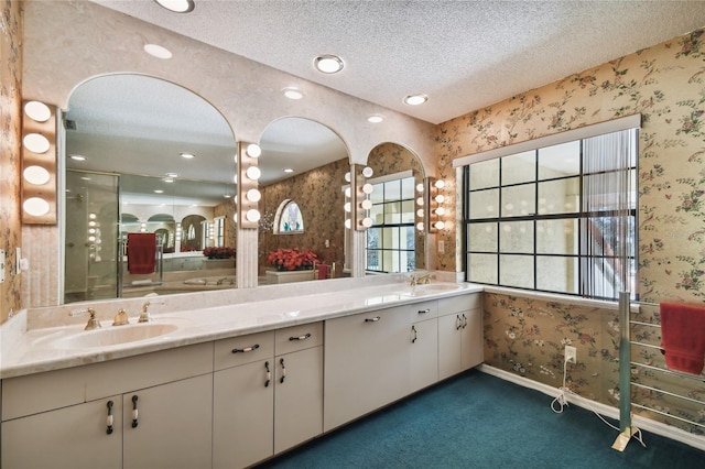 bathroom featuring a textured ceiling and dual bowl vanity