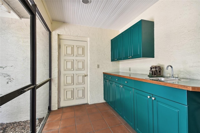 kitchen featuring dark tile flooring and sink