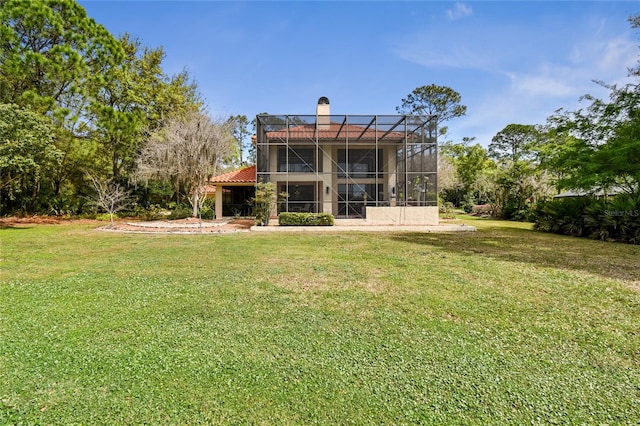 rear view of property featuring a lanai and a yard