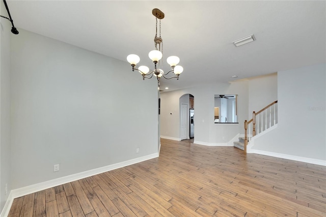 unfurnished room featuring light hardwood / wood-style flooring and ceiling fan with notable chandelier