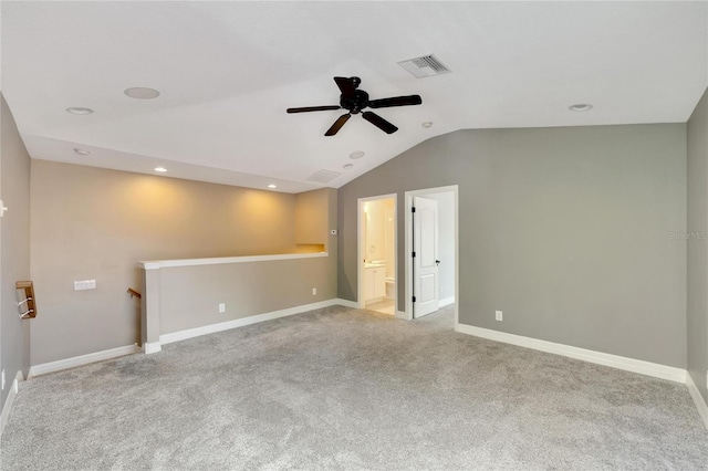 carpeted spare room with ceiling fan and vaulted ceiling