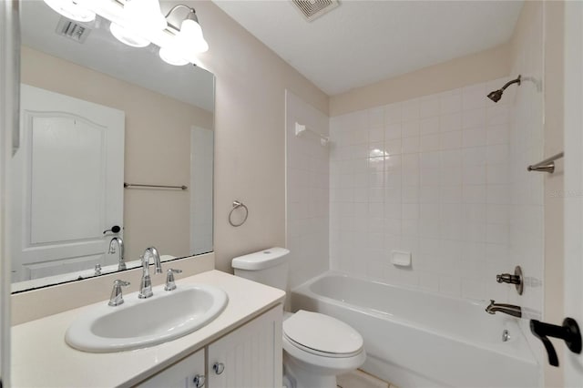 full bathroom with vanity, tiled shower / bath combo, and toilet