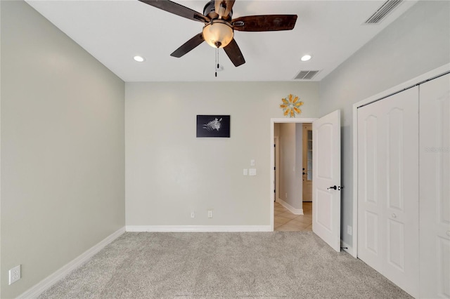 unfurnished bedroom featuring ceiling fan, light carpet, and a closet