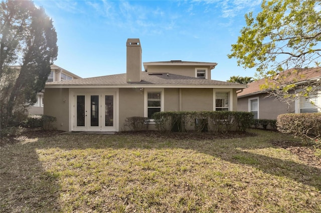 back of property featuring a yard and french doors