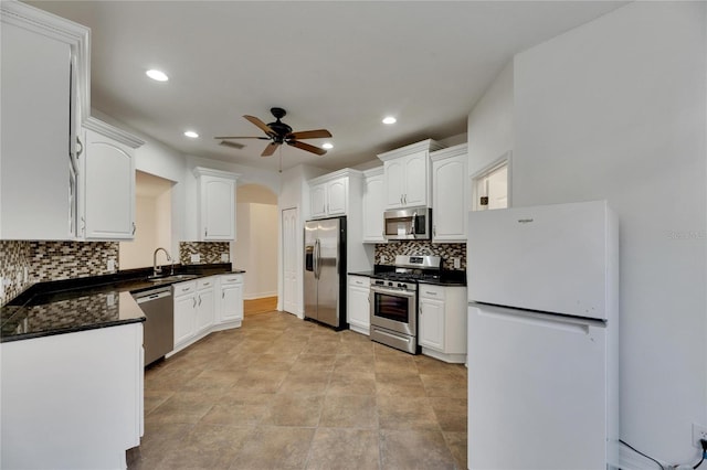 kitchen featuring ceiling fan, sink, backsplash, white cabinets, and appliances with stainless steel finishes