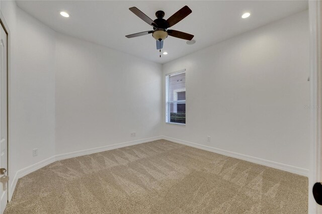 carpeted spare room with ceiling fan