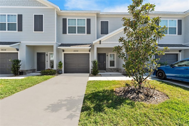 view of property featuring a garage and a front lawn