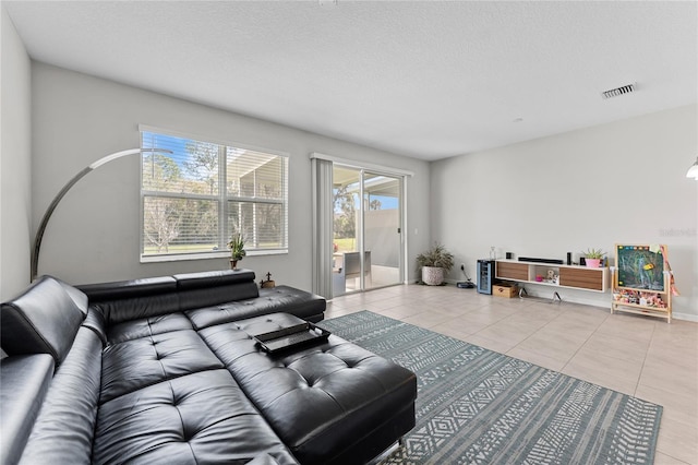 tiled living room featuring a textured ceiling