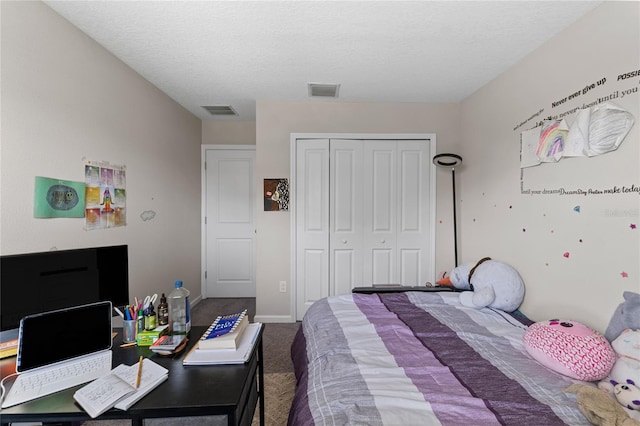 carpeted bedroom with a textured ceiling and a closet