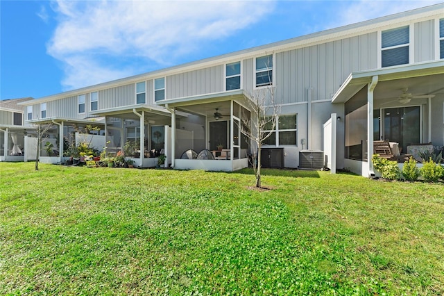 rear view of property featuring a sunroom, a yard, central AC unit, and ceiling fan