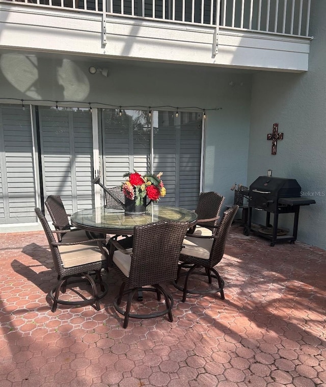 view of patio with a balcony and a grill