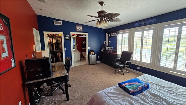 bedroom with connected bathroom, light colored carpet, ceiling fan, vaulted ceiling, and a textured ceiling