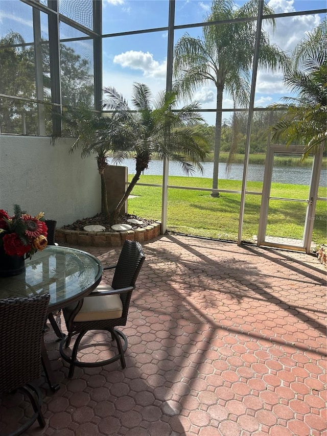 sunroom / solarium featuring a water view