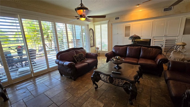 tiled living room featuring ornamental molding and ceiling fan