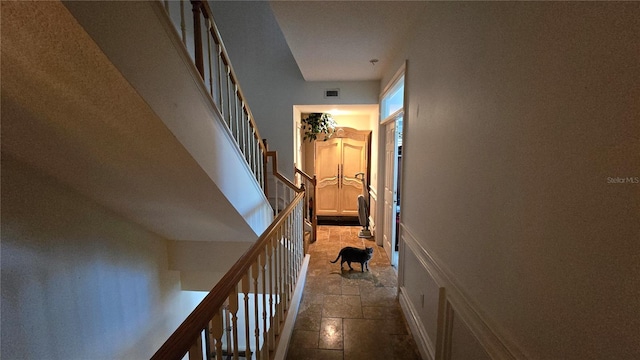 hallway featuring dark tile flooring