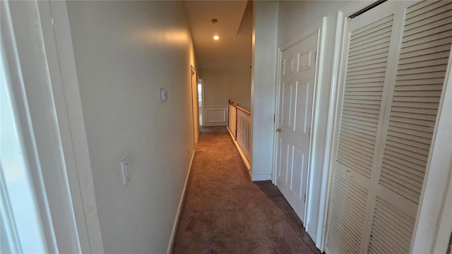 hallway with dark colored carpet