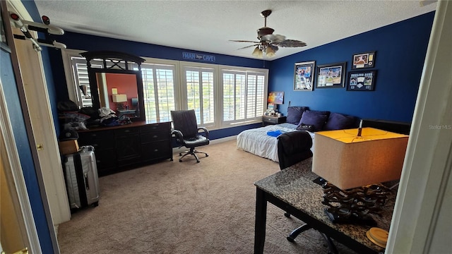 bedroom featuring light carpet, ceiling fan, and a textured ceiling