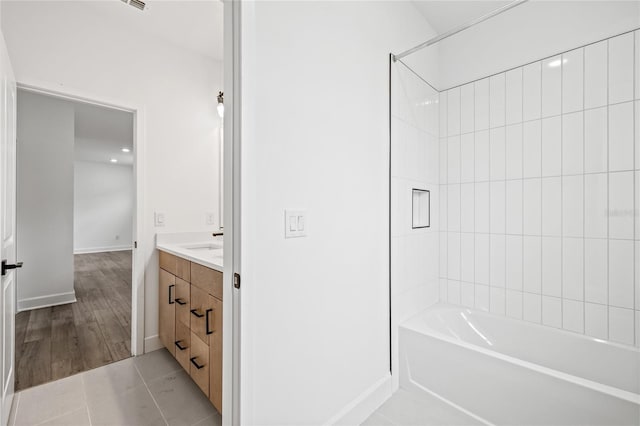 bathroom with vanity, tiled shower / bath combo, and wood-type flooring