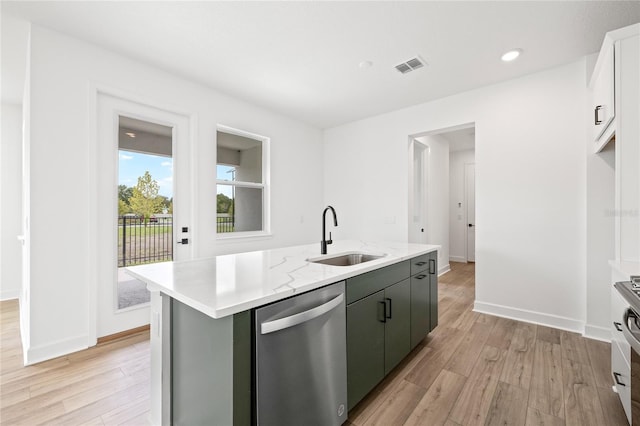 kitchen featuring stainless steel dishwasher, sink, a kitchen island with sink, and light hardwood / wood-style flooring