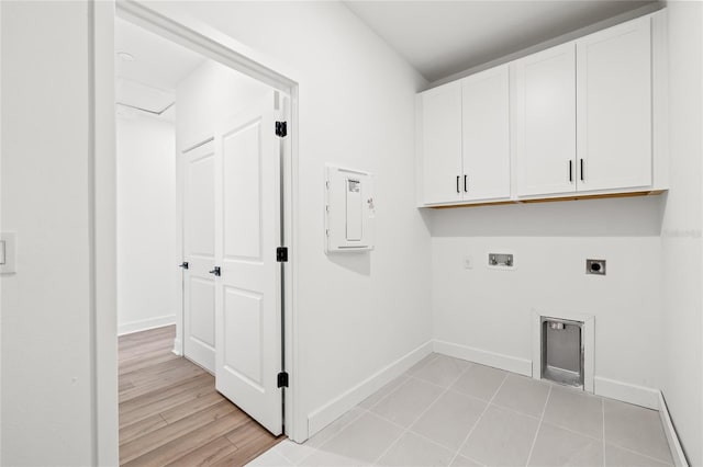 washroom with cabinets, electric panel, light wood-type flooring, hookup for a washing machine, and hookup for an electric dryer