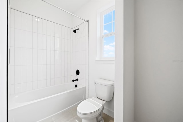 bathroom with toilet, tiled shower / bath combo, and tile patterned flooring