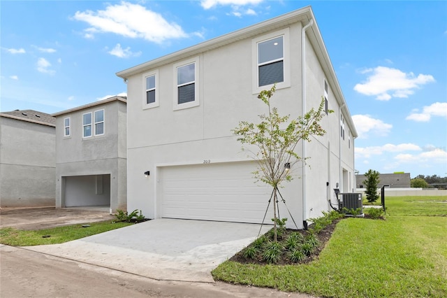 view of front of home with cooling unit, a front lawn, and a garage