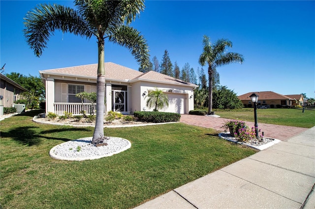 view of front facade with a front yard, a garage, and central air condition unit