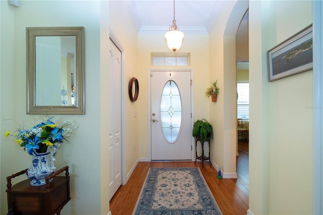 foyer entrance featuring ornamental molding and light wood-type flooring