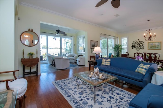 living room featuring dark hardwood / wood-style floors, ornamental molding, and ceiling fan with notable chandelier