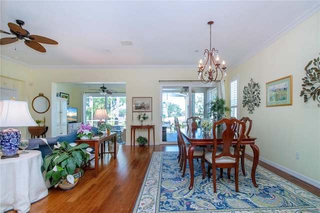 dining room with dark hardwood / wood-style floors, ceiling fan with notable chandelier, and ornamental molding