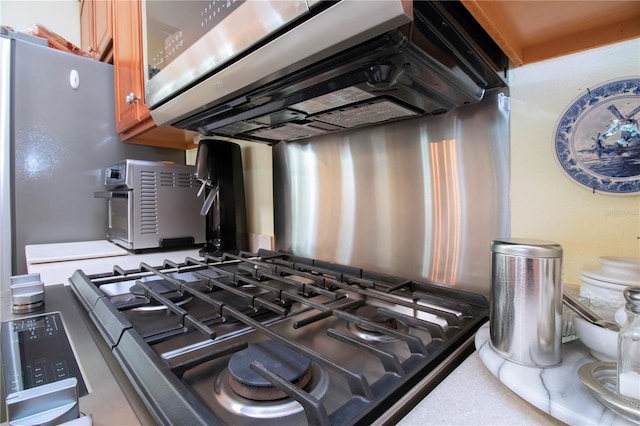 room details featuring range and wall chimney exhaust hood