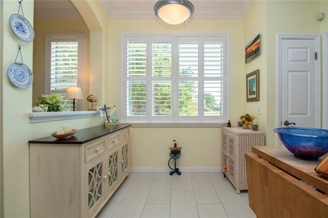 interior space with light tile floors and crown molding