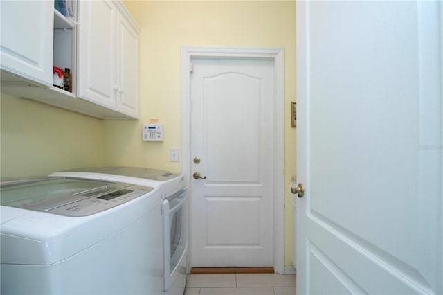 washroom with light tile floors, cabinets, and independent washer and dryer