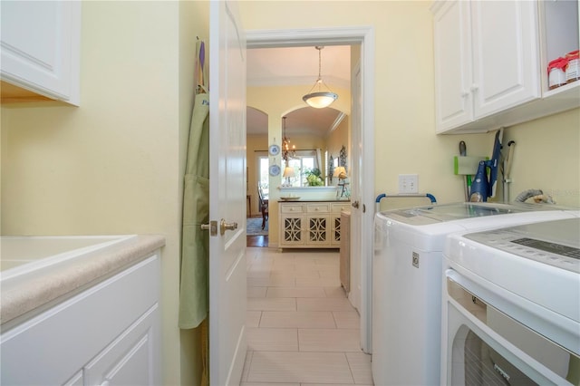 washroom featuring light tile floors, cabinets, crown molding, and washer and clothes dryer