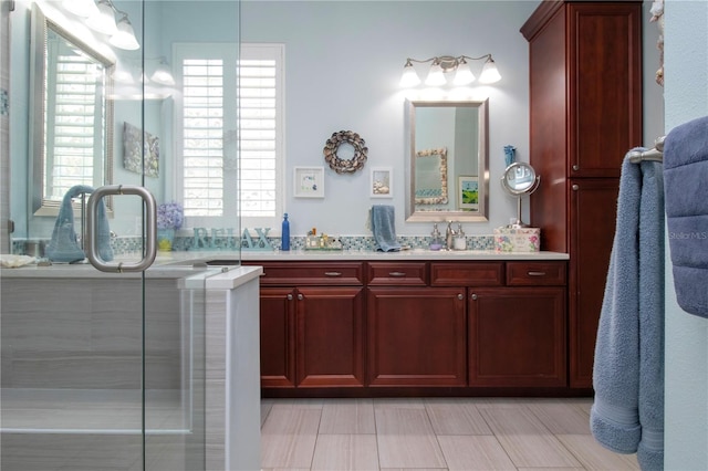 bathroom featuring an enclosed shower, tile flooring, dual sinks, and vanity with extensive cabinet space